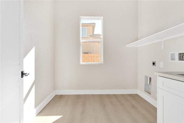 clothes washing area featuring cabinets, light hardwood / wood-style flooring, washer hookup, and electric dryer hookup