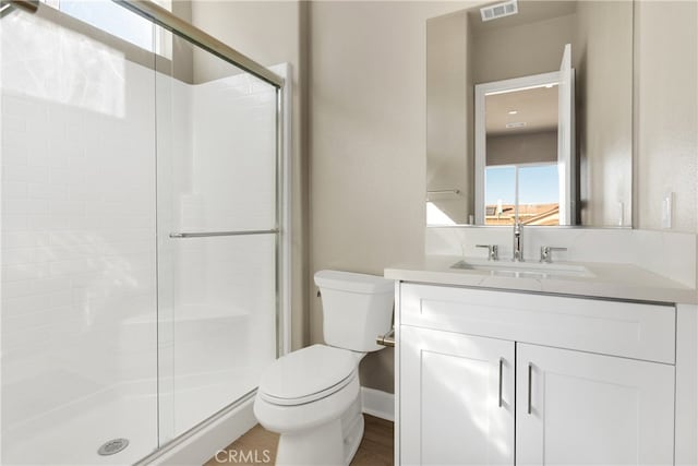 bathroom with toilet, walk in shower, and vanity