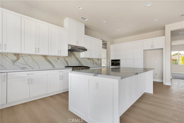 kitchen with appliances with stainless steel finishes, a kitchen island, and white cabinets