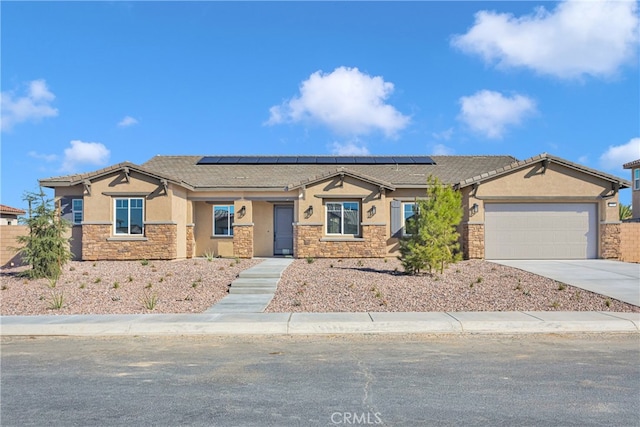 ranch-style home with a garage and solar panels