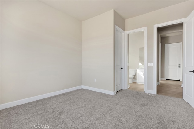 unfurnished bedroom with light carpet and ensuite bath