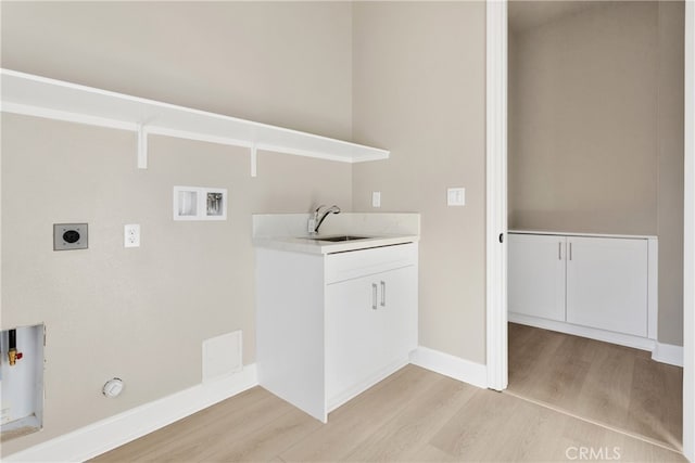 clothes washing area featuring hookup for a washing machine, electric dryer hookup, light hardwood / wood-style floors, hookup for a gas dryer, and sink