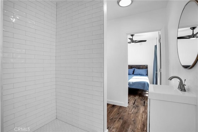 bathroom featuring a tile shower, vanity, and hardwood / wood-style flooring