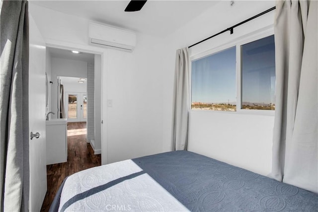 bedroom featuring a wall unit AC, ceiling fan, and dark wood-type flooring