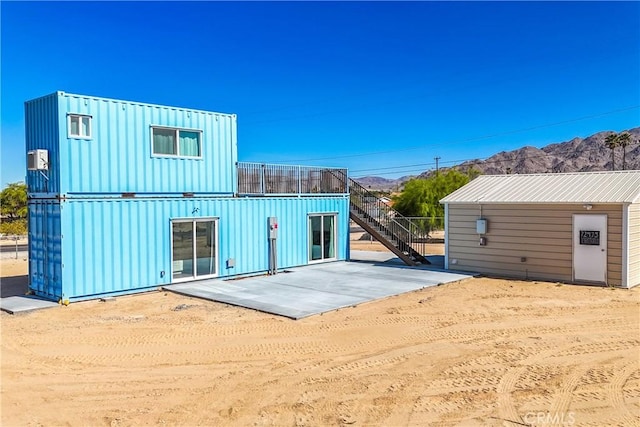 rear view of house featuring a mountain view and a patio