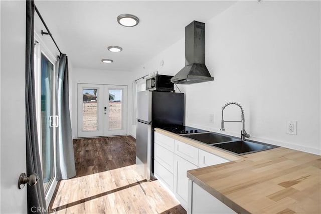 kitchen with french doors, ventilation hood, sink, light hardwood / wood-style flooring, and white cabinets