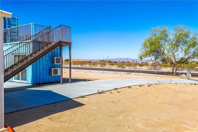 view of patio / terrace featuring a mountain view and a wall mounted air conditioner