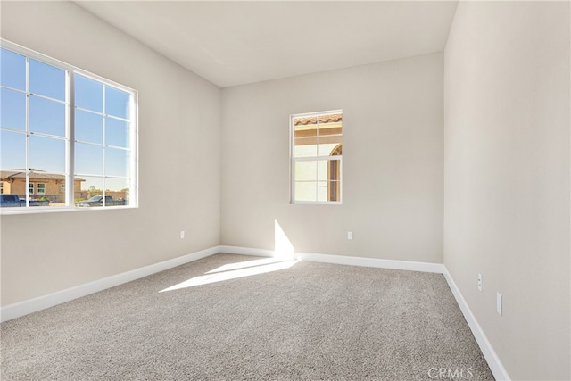 carpeted spare room featuring plenty of natural light