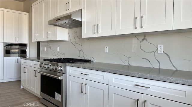 kitchen featuring light hardwood / wood-style flooring, white cabinets, stainless steel appliances, and backsplash