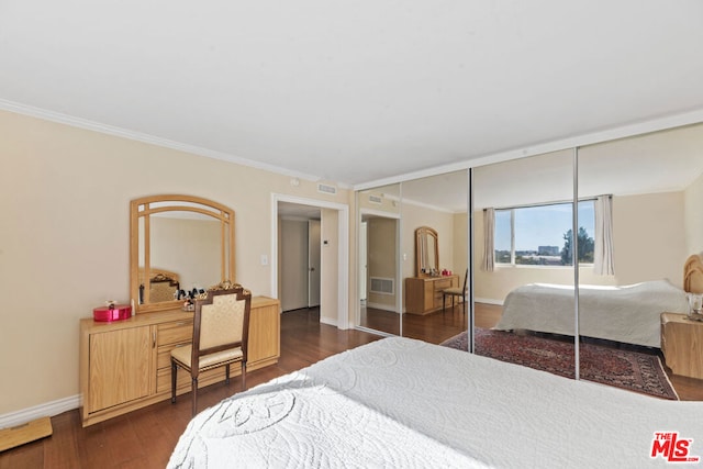 bedroom featuring dark hardwood / wood-style floors, a closet, and crown molding