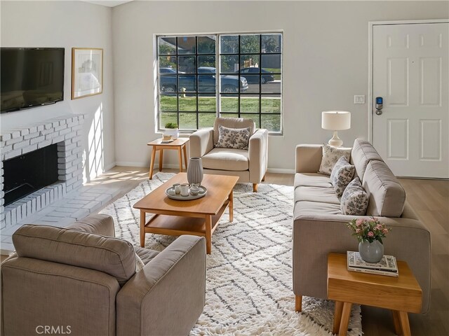 living room with a fireplace and light wood-type flooring