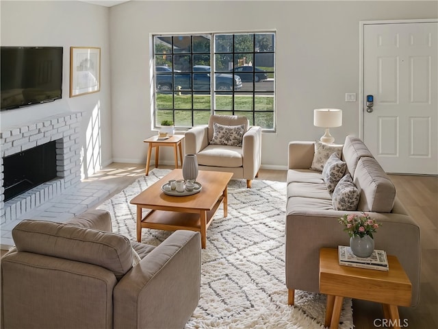 living room with a brick fireplace and light wood-type flooring