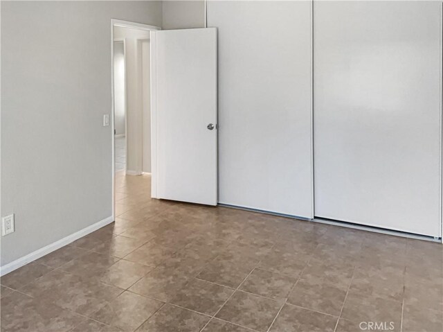 unfurnished bedroom featuring tile patterned flooring and a closet