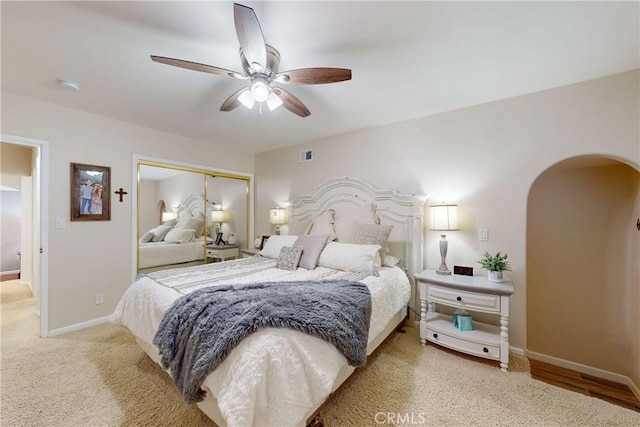 carpeted bedroom featuring ceiling fan and a closet