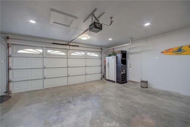 garage with white fridge and a garage door opener