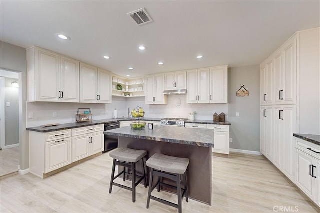 kitchen featuring gas stove, white cabinetry, a center island, black dishwasher, and light hardwood / wood-style floors