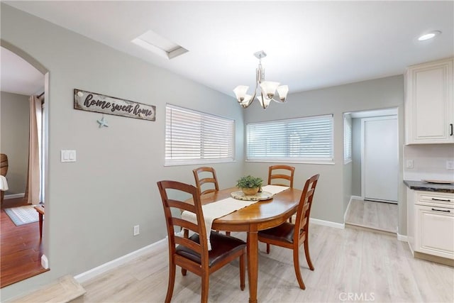 dining area featuring light hardwood / wood-style flooring and a notable chandelier