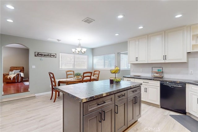 kitchen with a kitchen island, light wood-type flooring, decorative light fixtures, and black dishwasher