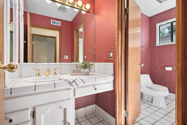 bathroom featuring toilet, tile patterned flooring, and vanity