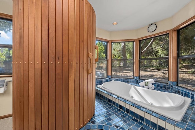 bathroom featuring tile patterned flooring and tiled bath