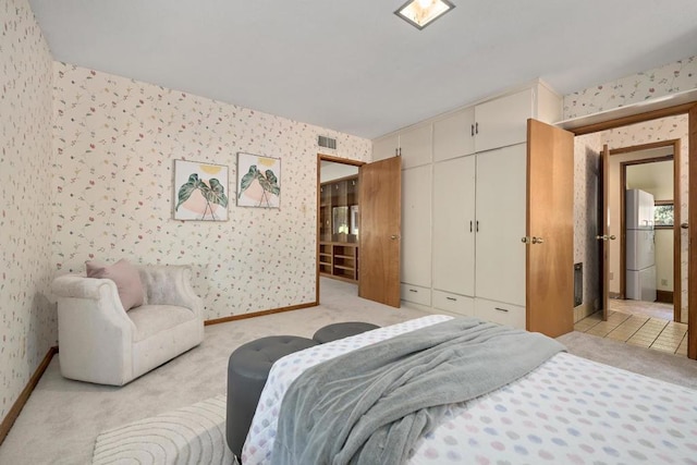 carpeted bedroom with white refrigerator and a closet