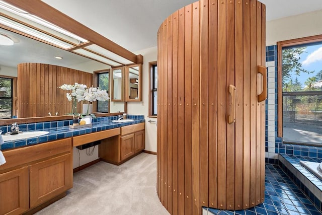 bathroom with vanity and tiled tub