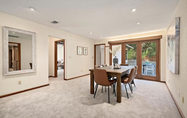 dining space with french doors and light colored carpet