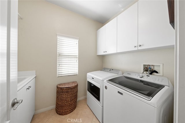 laundry room with cabinets, light tile patterned floors, and washing machine and clothes dryer