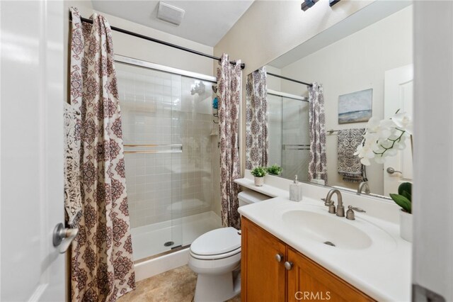 bathroom with toilet, a shower with shower door, and vanity