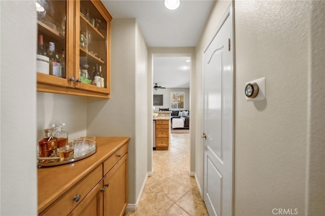 bar featuring baseboards, a ceiling fan, and light tile patterned flooring