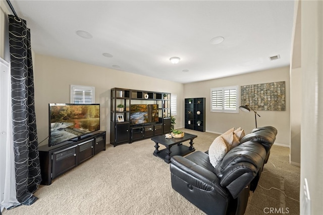 living room featuring baseboards, visible vents, and light colored carpet