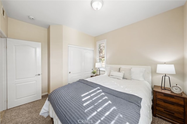 carpeted bedroom featuring a closet and visible vents