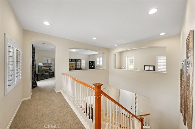 hall featuring light colored carpet