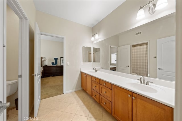 bathroom featuring toilet, tile patterned flooring, and vanity