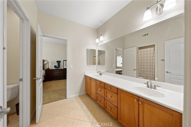 bathroom featuring visible vents, a sink, toilet, and double vanity