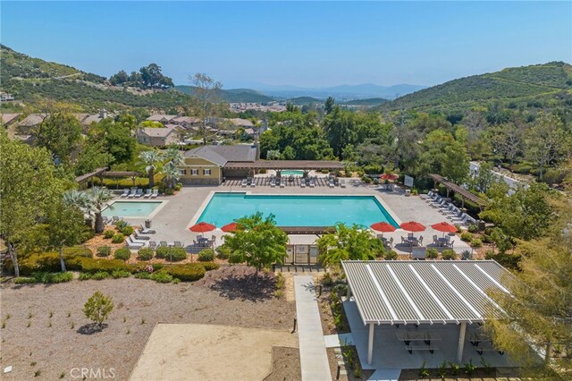 view of swimming pool with a mountain view, a patio area, and a pergola