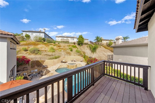 deck with a patio area and a swimming pool with hot tub