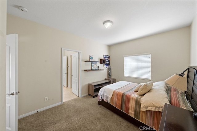 bedroom with light colored carpet and baseboards