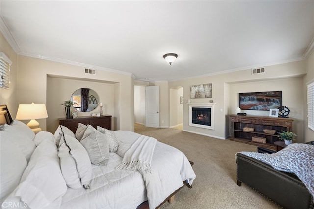 bedroom with carpet, visible vents, ornamental molding, and a glass covered fireplace