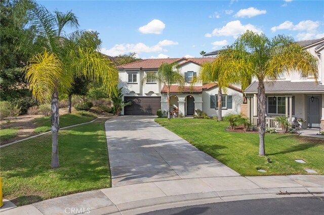 mediterranean / spanish house featuring a front yard and a garage