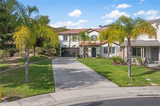 mediterranean / spanish home with a garage, driveway, a tiled roof, stucco siding, and a front lawn