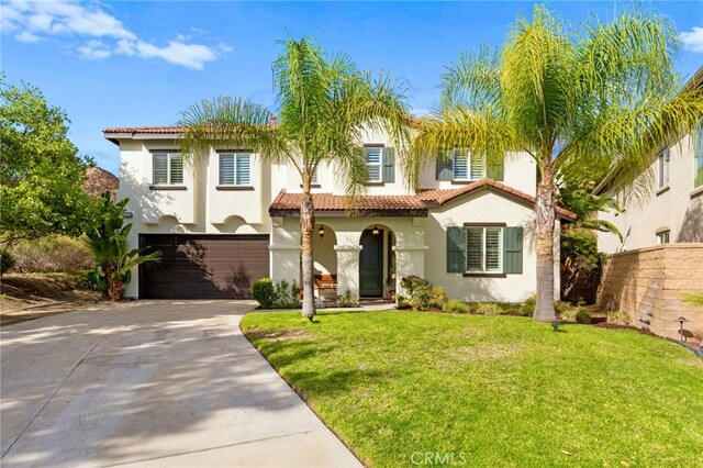 mediterranean / spanish-style house with a front yard and a garage