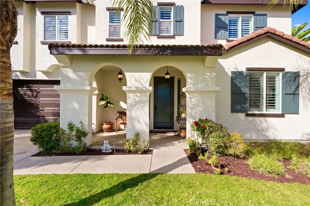 property entrance with a tiled roof and stucco siding