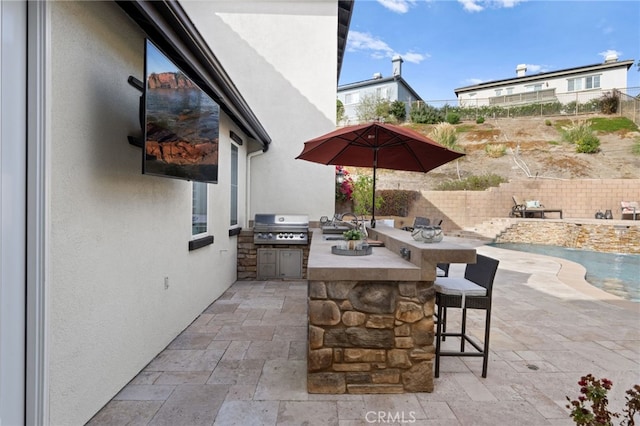 view of patio featuring a wet bar, an outdoor kitchen, and area for grilling