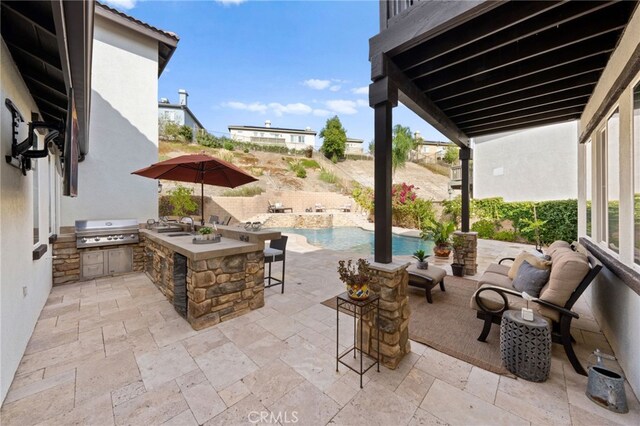 view of patio / terrace featuring grilling area, an outdoor kitchen, and a wet bar