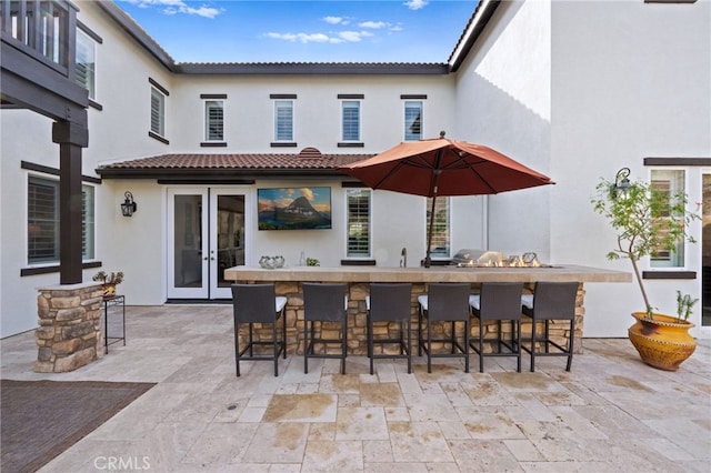 view of patio / terrace with outdoor wet bar, french doors, and a sink