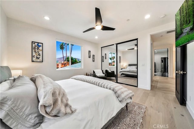 bedroom featuring a closet, recessed lighting, and light wood-type flooring