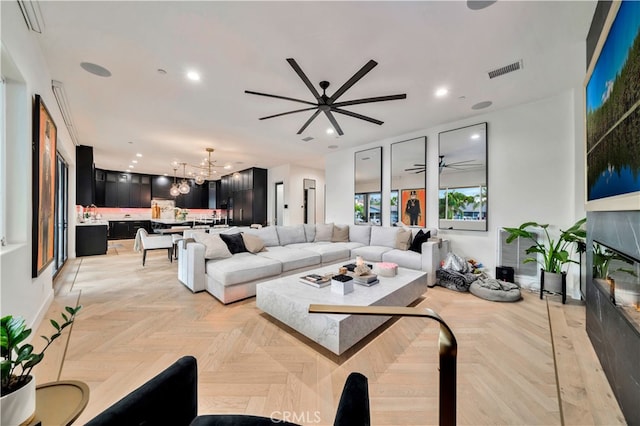 living room featuring light parquet floors and ceiling fan with notable chandelier