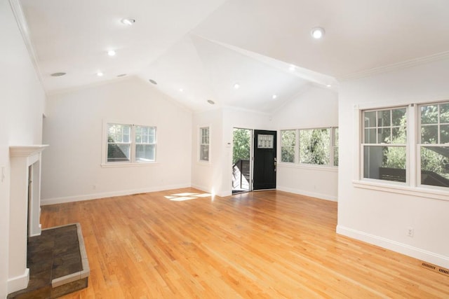 unfurnished living room featuring a tile fireplace, lofted ceiling, light hardwood / wood-style flooring, and crown molding