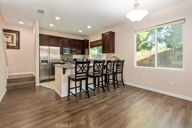 kitchen with dark hardwood / wood-style flooring, appliances with stainless steel finishes, and plenty of natural light